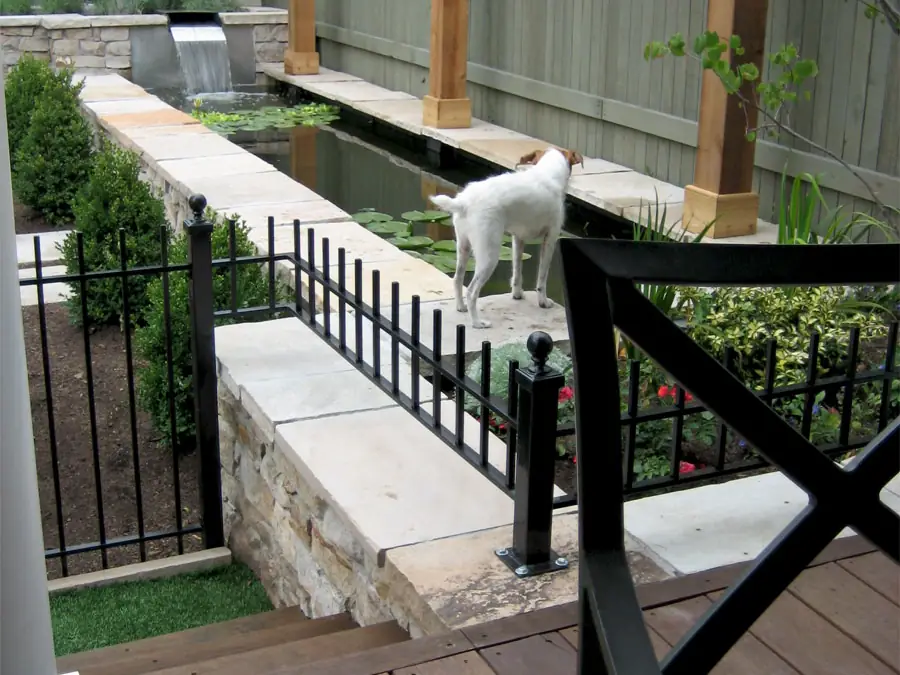 Raised stone-veneered beds and synthetic turf in the City Park West courtyard