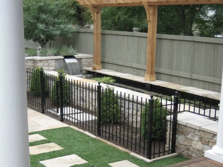 City Park West courtyard with a wooden arbor over the koi pond and iron fencing