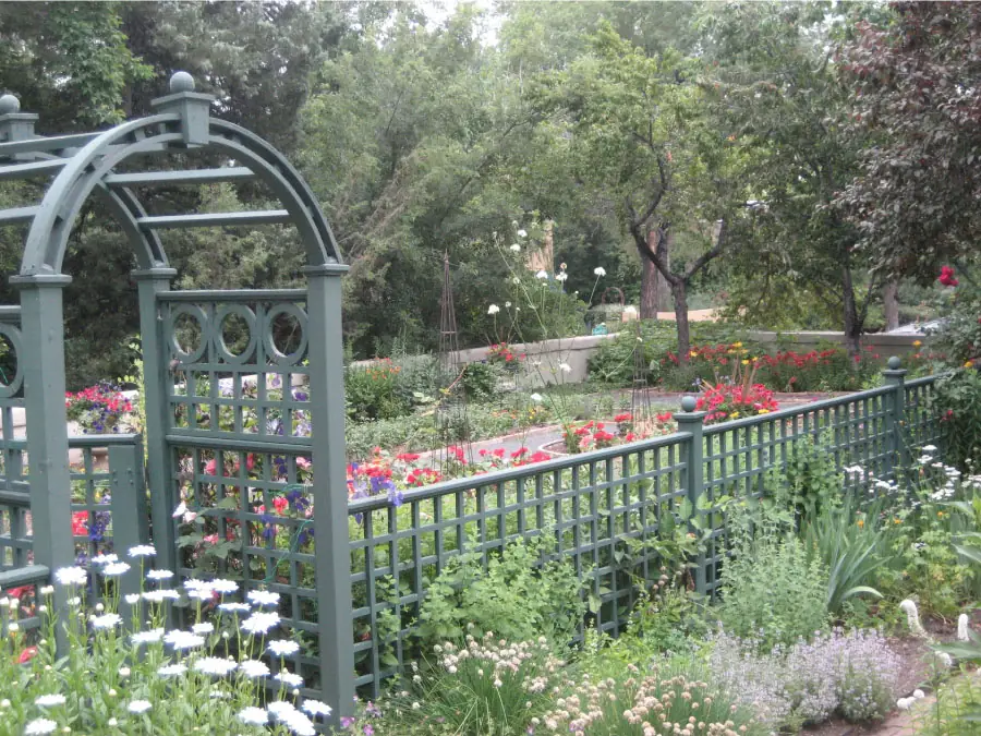 Potager Garden with a green trellis arch and flowering beds