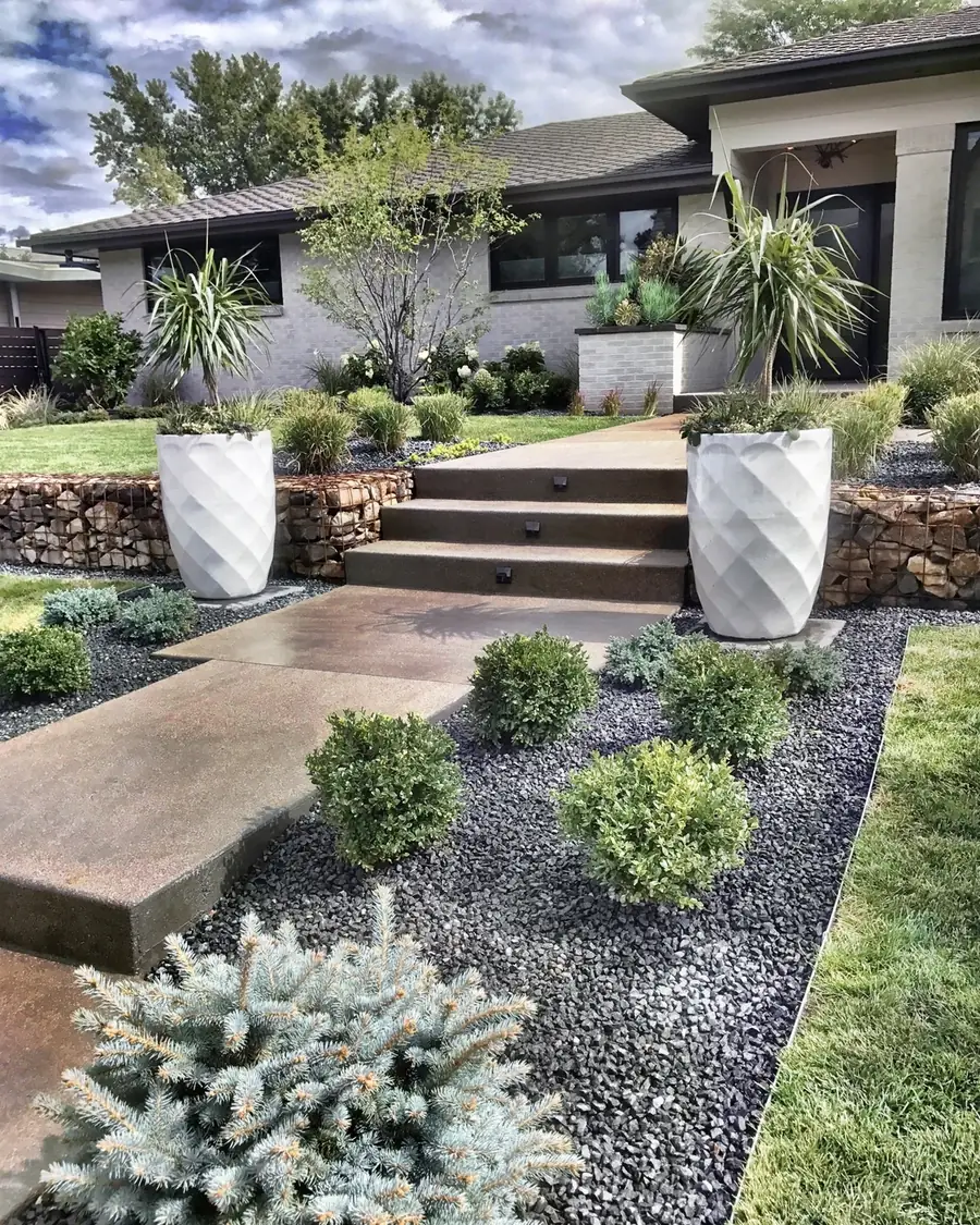 Modern front walk with white planters and layered beds by Stonegate Gardens